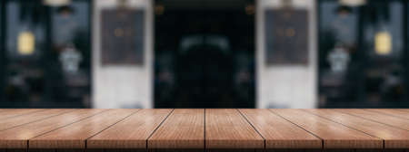 Empty wooden table top with lights bokeh on blur restaurant background.