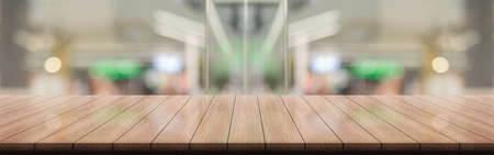Empty wooden table top with lights bokeh on blur restaurant background.