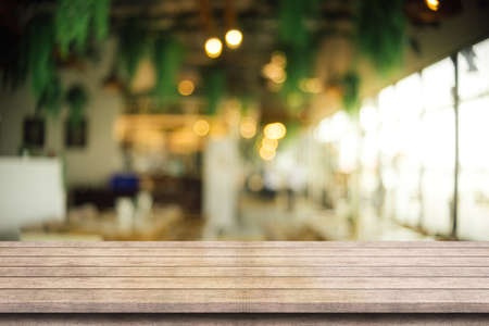 Empty wooden table top with lights bokeh on blur restaurant background.の写真素材