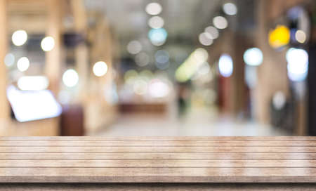 Empty wooden table top with lights bokeh on blur restaurant background.の写真素材