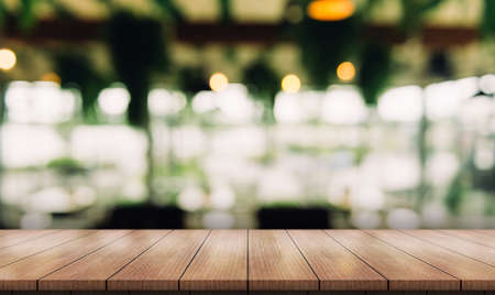 Empty wooden table top with lights bokeh on blur restaurant background.の写真素材