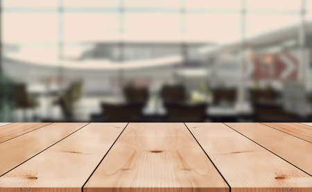 Empty wooden table top with lights bokeh on blur restaurant background.の写真素材