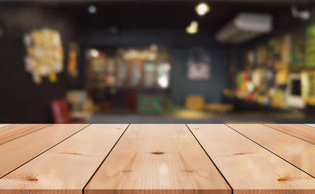 Empty wooden table top with lights bokeh on blur restaurant background.の写真素材
