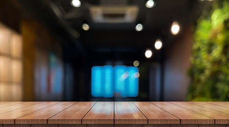 Empty wooden table top with lights bokeh on blur restaurant background.