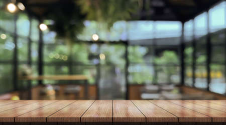 Empty wooden table top with lights bokeh on blur restaurant background.の写真素材