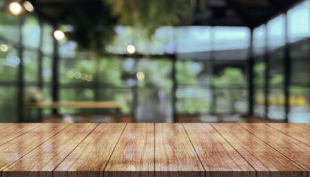 Empty wooden table top with lights bokeh on blur restaurant background.の写真素材