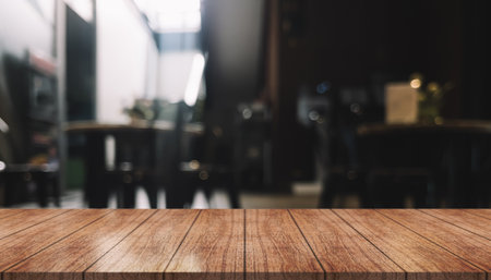 Empty wooden table top with lights bokeh on blur restaurant background.の写真素材