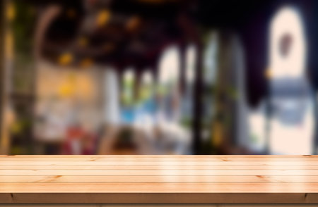 Empty wooden table top with lights bokeh on blur restaurant background.の写真素材