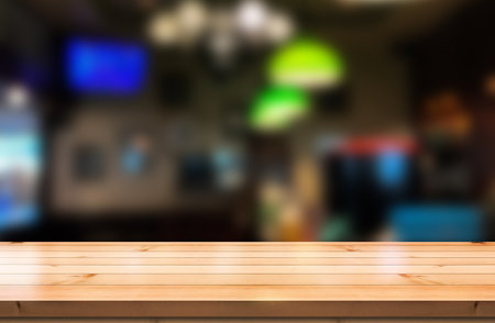 Empty wooden table top with lights bokeh on blur restaurant background.の写真素材