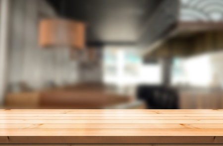 Empty wooden table top with lights bokeh on blur restaurant background.の写真素材