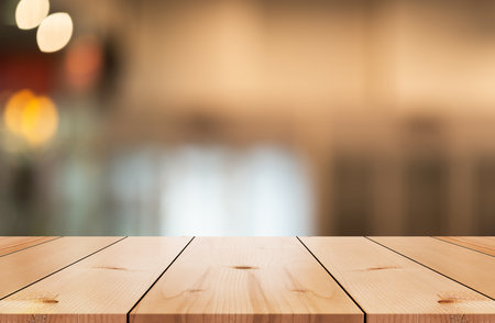 Empty wooden table top with lights bokeh on blur restaurant background.の写真素材