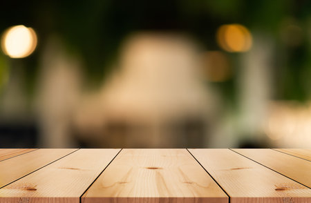 Empty wooden table top with lights bokeh on blur restaurant background.の写真素材