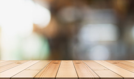 Empty wooden table top with lights bokeh on blur restaurant background.の写真素材