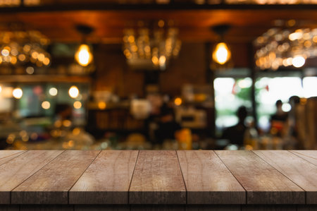 Empty wooden table top with lights bokeh on blur restaurant background.の写真素材