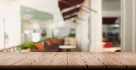 Empty wooden table top with lights bokeh on blur restaurant background.の写真素材