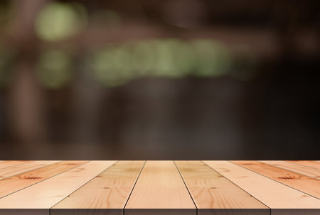 Empty wooden table top with lights bokeh on blur restaurant background.の写真素材