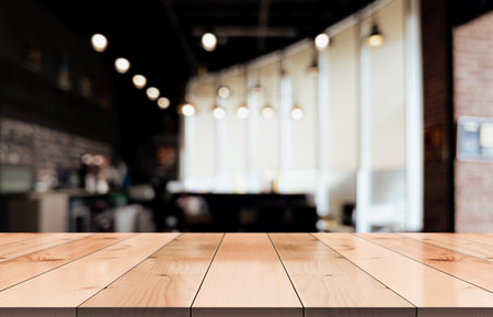 Empty wooden table top with lights bokeh on blur restaurant background.の写真素材