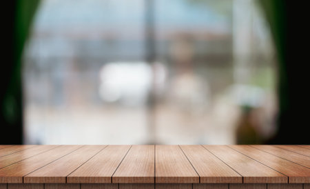 Empty wooden table top with lights bokeh on blur restaurant background.の写真素材