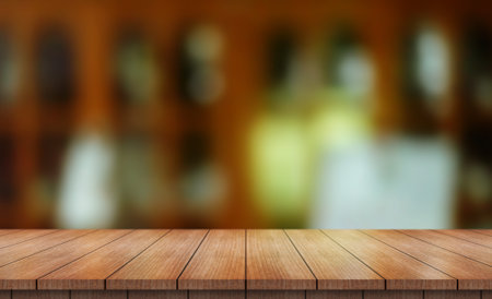 Empty wooden table top with lights bokeh on blur restaurant background.