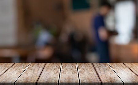 Empty wooden table top with lights bokeh on blur restaurant background.