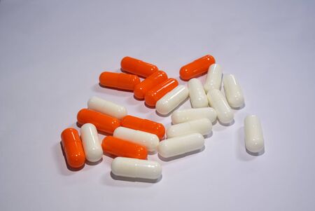 Orange and white capsules on a white backgroundの写真素材
