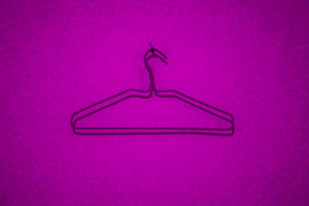 purple clothes hanger on the red backgroundの写真素材