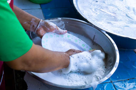 Woman washing dishes in the sinkの写真素材
