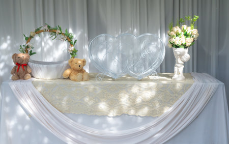 Heart box and teddy bear beside the basket on the table covered with white cloth. , Weddingの写真素材