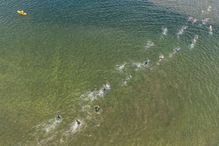 Triathlon swimming contest in lake swimmers competition aerial drone photo