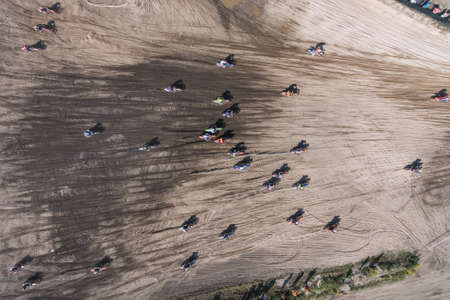 Motocross riders ride on a dust terrain track aerial drone photoの写真素材