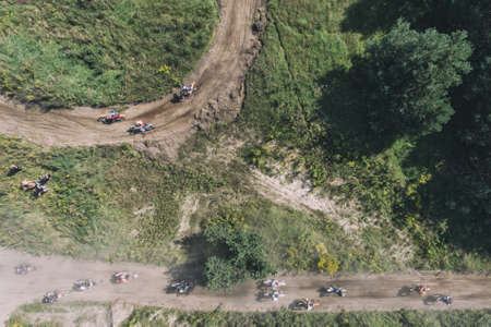 Motocross riders ride on a dust terrain track aerial drone photo