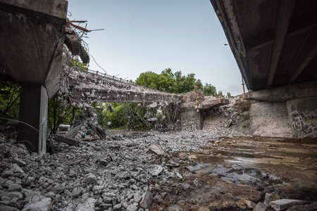 Orange excavator digger demolishing bridgeの写真素材