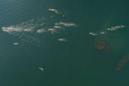 Triathlon swimming contest in lake swimmers competition aerial drone photoの写真素材
