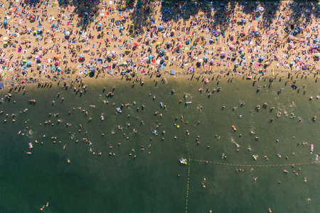Holiday vacation on the sandy beach, sunbathing and swimming in the water aerial drone photoの写真素材