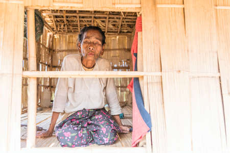 MRAUK U, RAKHINE STATE / MYANMAR - 7 December 2015: Portrait of an old Chin woman with a tattoo on...