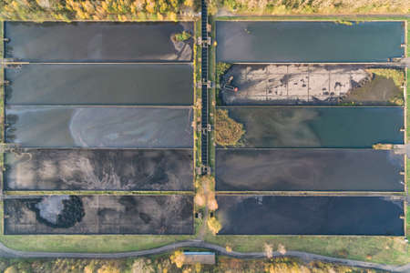 Abstract sendimentation tank of ironworks, excavator working, water treatment plant in Dabrowa...