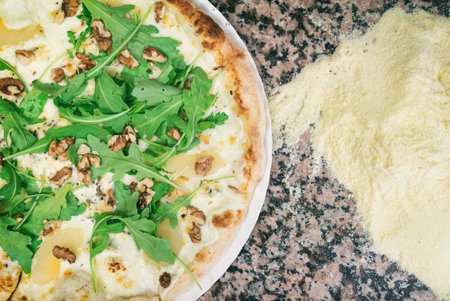 Pizza from the oven. Oven-baked pizza with pear and nuts close up viewの写真素材