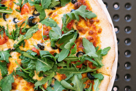 Vegetarian Pizza from the oven. Oven-baked vege pizza with arugula cheese and olives close up viewの写真素材