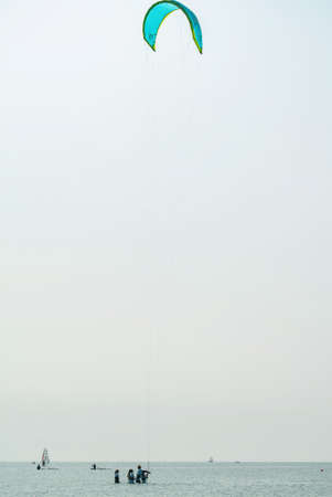 People swim in the sea on a kiteboard or kitesurfing. Summer sport learning how to kitesurf. Kite...