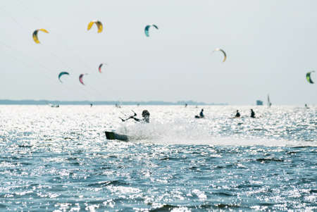 People swim in the sea on a kiteboard or kitesurfing. Summer sport learning how to kitesurf. Kite surfing on Puck bay in Jastarnia, Poland, Europeの写真素材