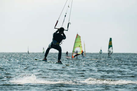 Kiteboard or kitesurfing tricks. Summer sport learning how to kitesurf. Kite surfing on Puck bay in Jastarnia, Poland, Europeの写真素材