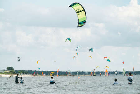 People swim in the sea on a kiteboard or kitesurfing. Summer sport learning how to kitesurf. Kite surfing on Puck bay in Jastarnia, Poland, Europeの写真素材