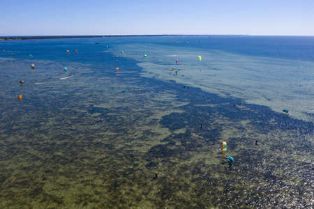 People swim in the sea on a kiteboard or kitesurfing. Summer sport learning how to kitesurf. Kite surfing on Puck bay in Jastarnia, Poland, Europe aerial drone photo viewのeditorial素材