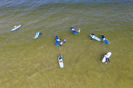 Aerial drone view of people surfing in the sea. Summer sport learning how to surf. Surfboarding in baltic sea Jastarnia, Poland, Europeのeditorial素材