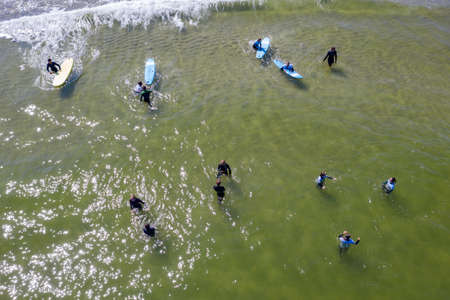 Aerial drone view of people surfing in the sea. Summer sport learning how to surf. Surfboarding in baltic sea Jastarnia, Poland, Europeのeditorial素材