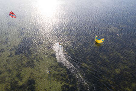 People swim in the sea on a kiteboard or kitesurfing. Summer sport learning how to kitesurf. Kite...