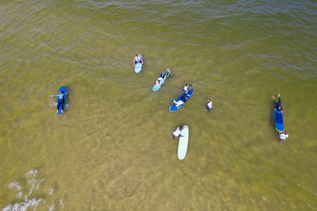 Aerial drone view of people surfing in the sea. Summer sport learning how to surf. Surfboarding in baltic sea Jastarnia, Poland, Europeのeditorial素材