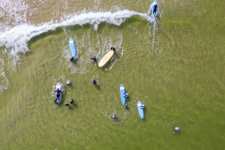 Aerial drone view of people surfing in the sea. Summer sport learning how to surf. Surfboarding in baltic sea Jastarnia, Poland, Europeのeditorial素材