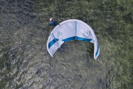 People swim in the sea on a kiteboard or kitesurfing. Summer sport learning how to kitesurf. Kite...