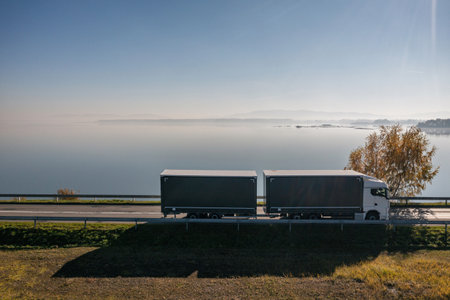Truck goes on the road in autumn. car transportation . Truck with semi-trailer in gray color....